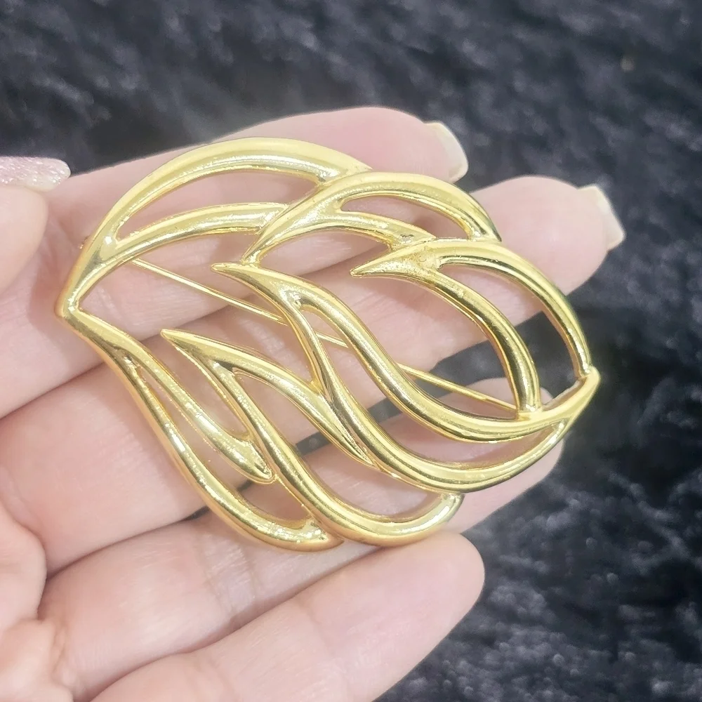 Monet Jewelry Two gold-tone leaf and penguin brooches